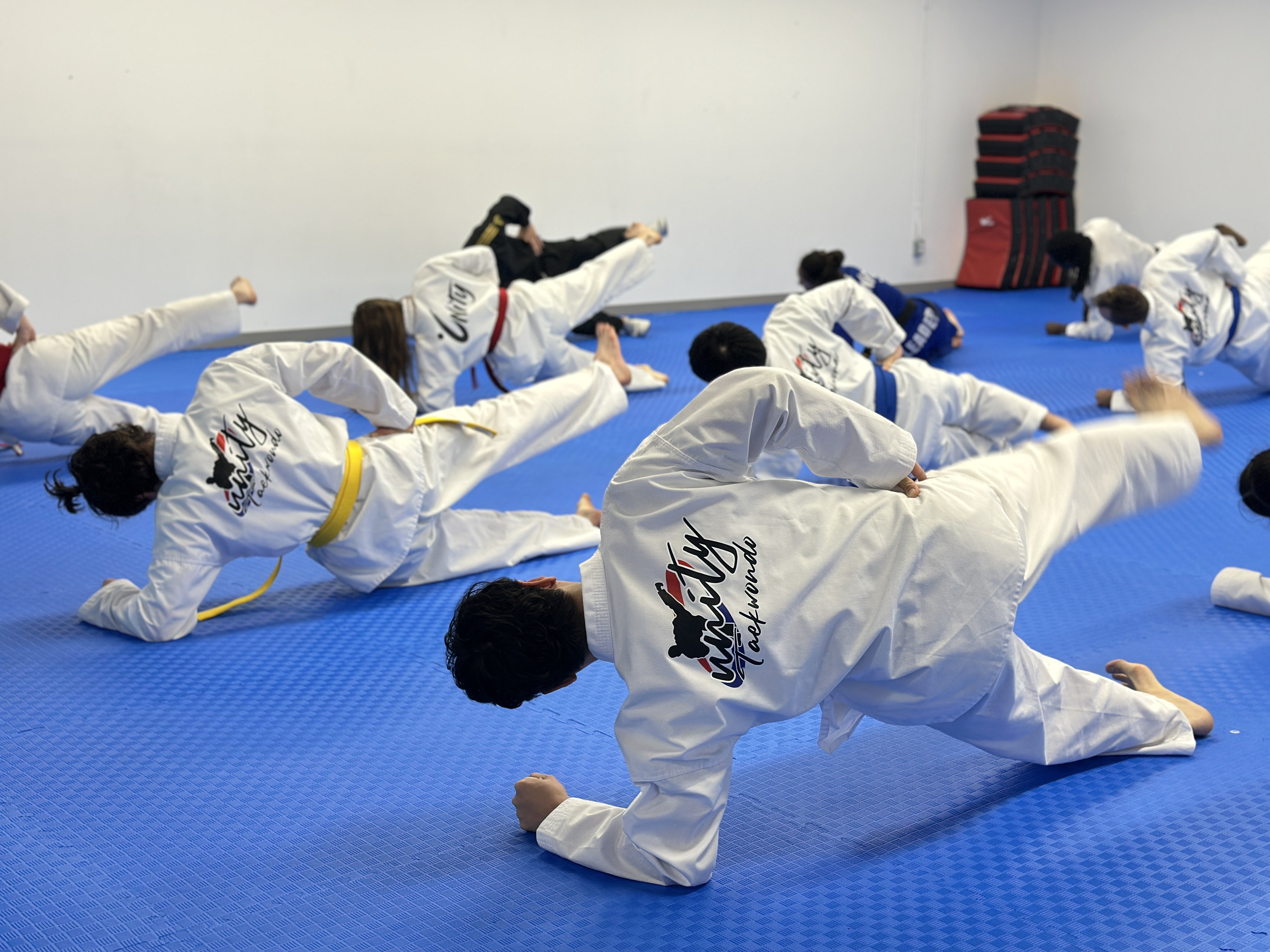 Teen and adult students practicing side-kick drills in class at Unity Taekwondo Chilliwack