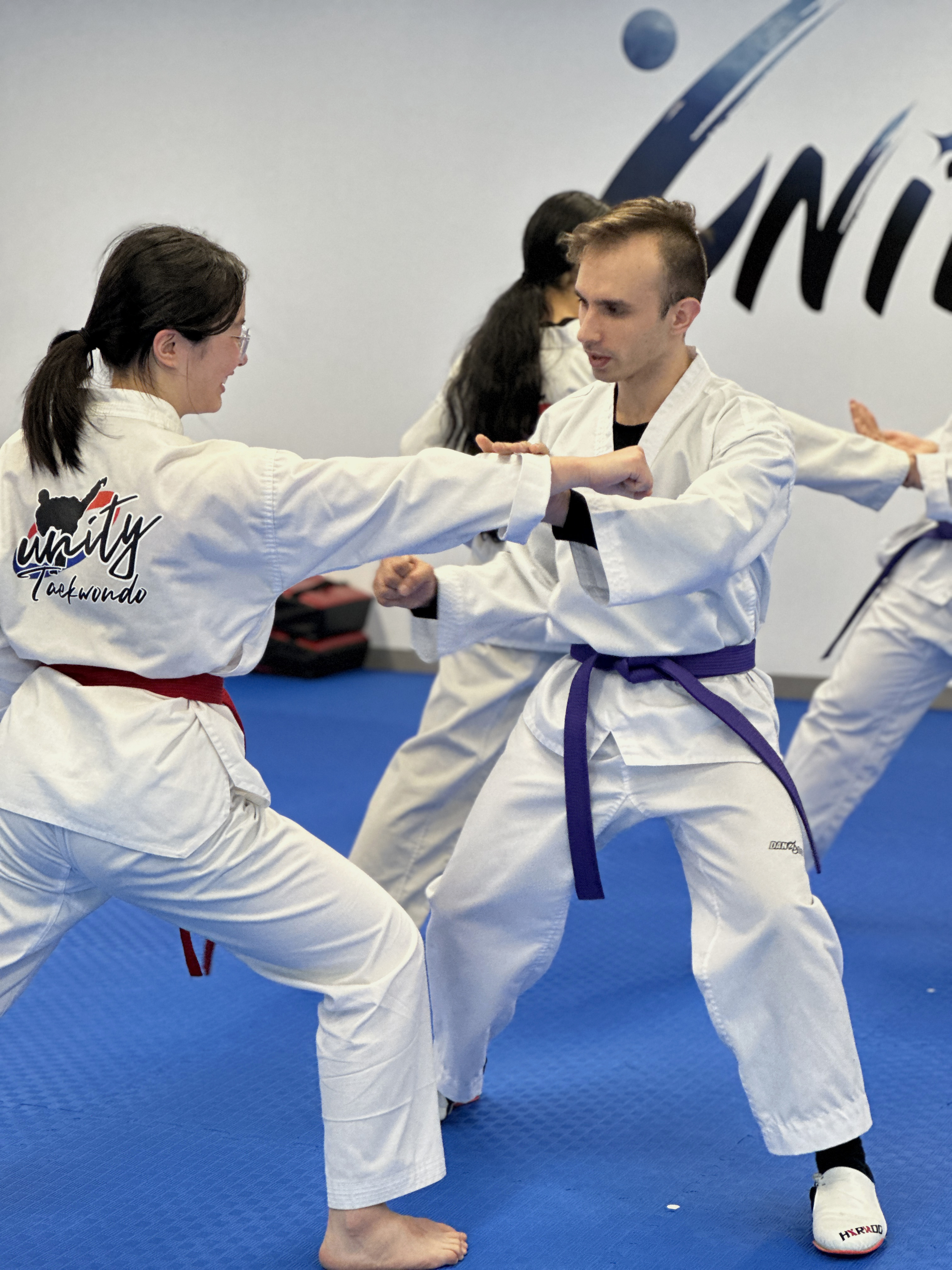 Two students practicing partner blocking drills at Unity Taekwondo Chilliwack