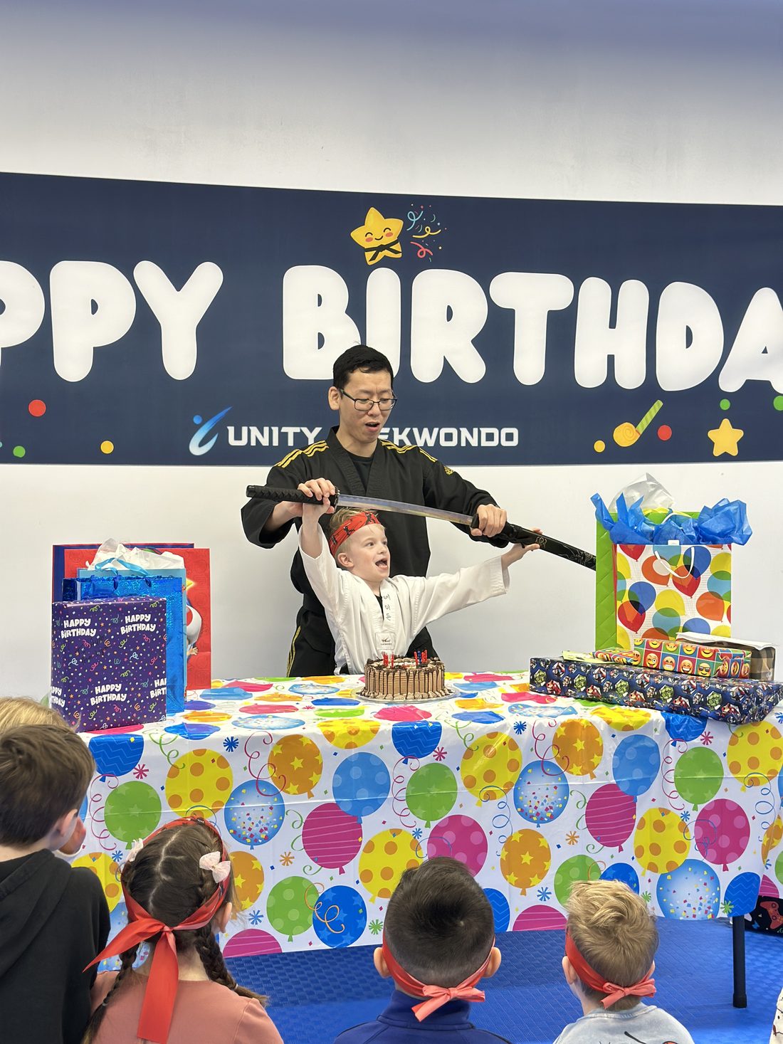 Children celebrating around the party table at a Unity Taekwondo birthday party