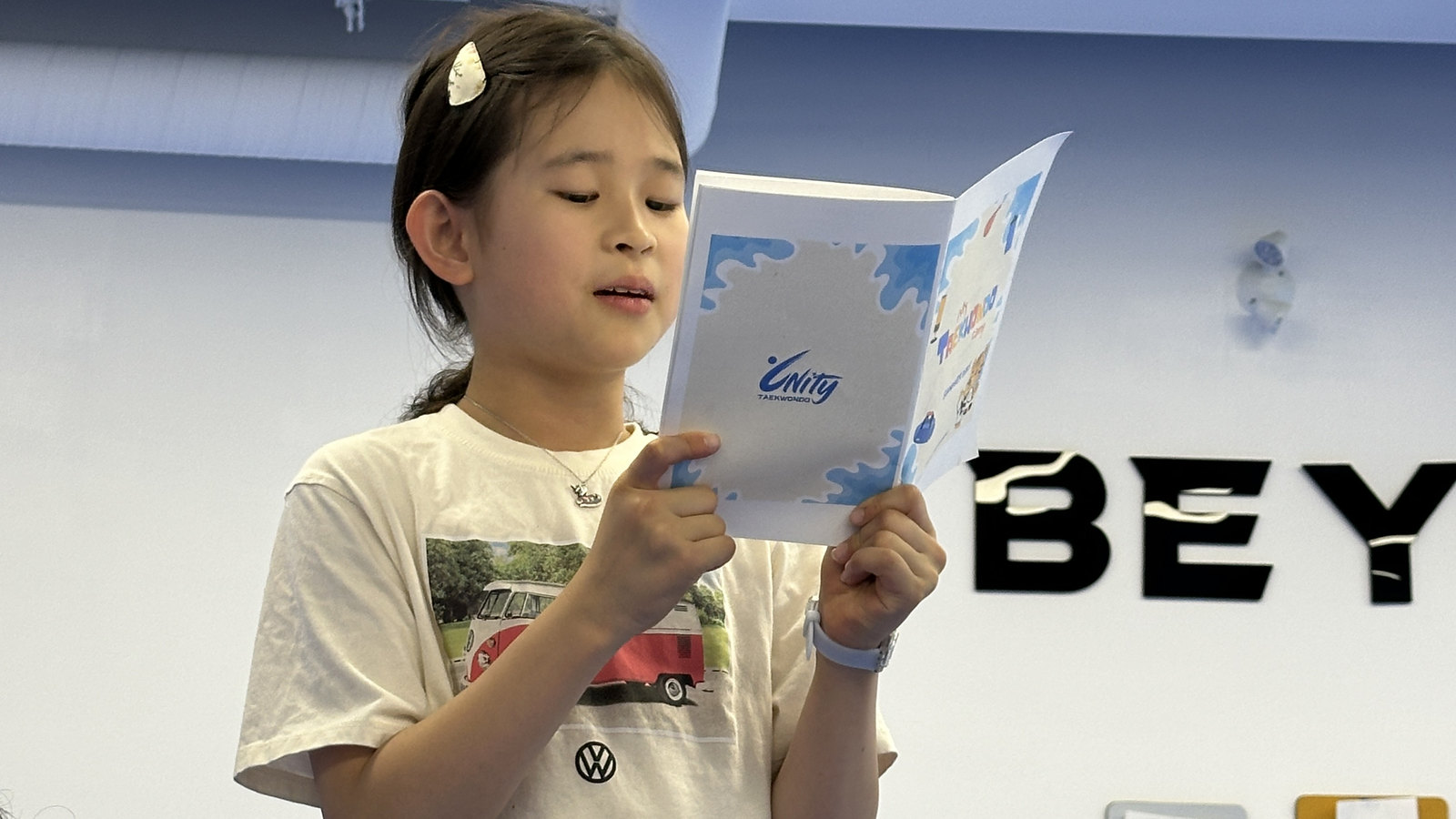 Camper reading her Unity Taekwondo booklet at Beyond the Belt Summer Camp in Chilliwack