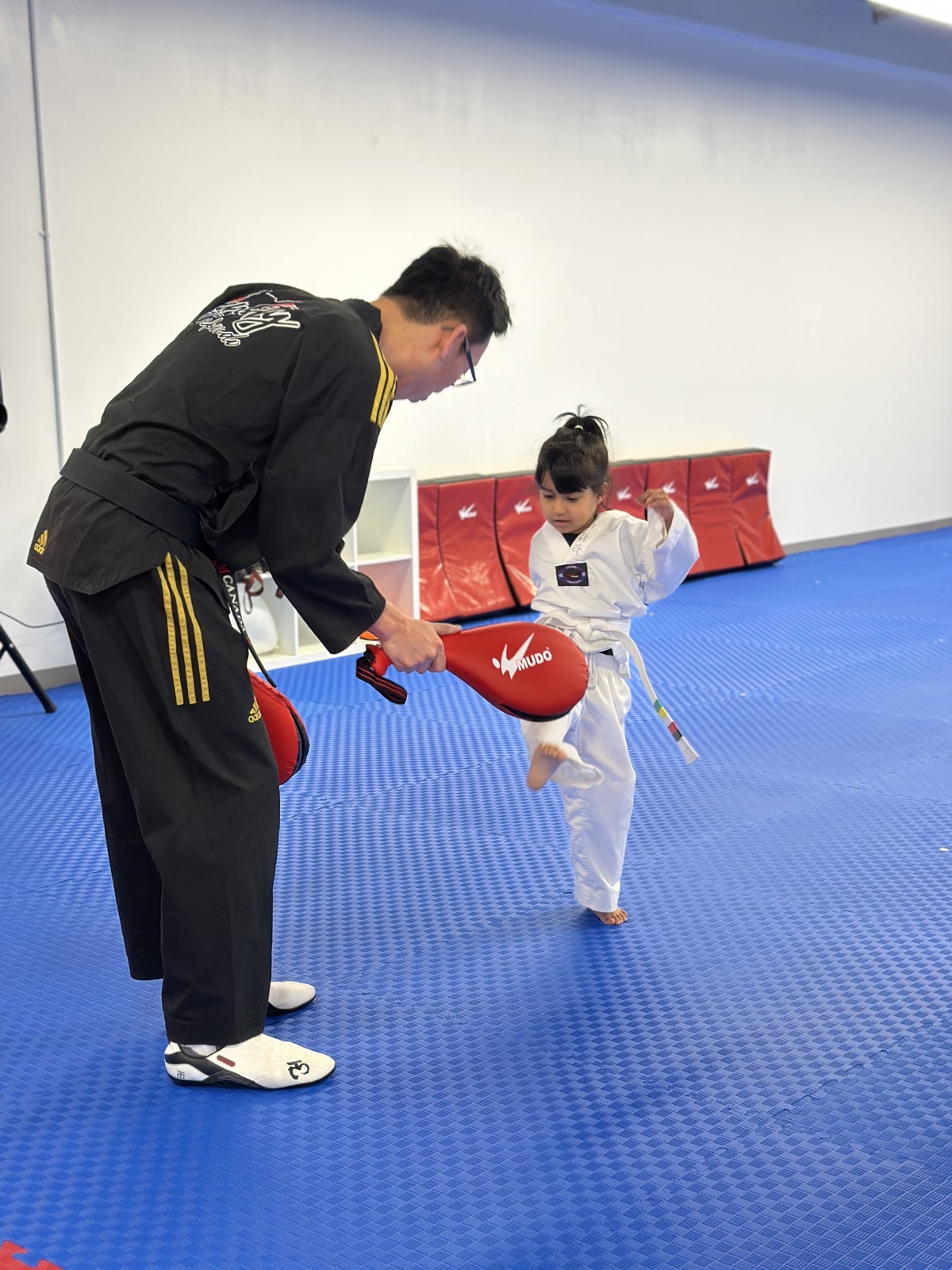 Master Deokho Nam coaching a young student one-on-one at Unity Taekwondo in Chilliwack