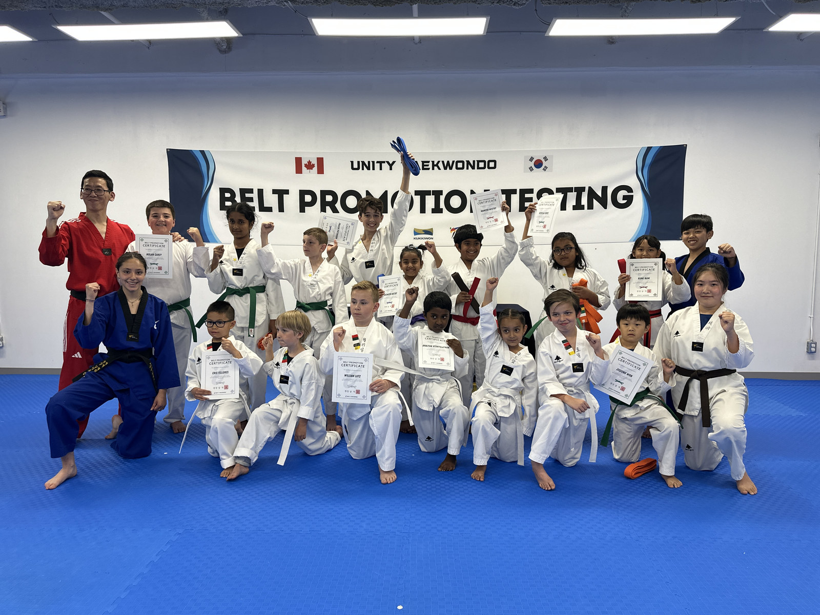 Young Unity Taekwondo students celebrating together after belt testing in Chilliwack, BC