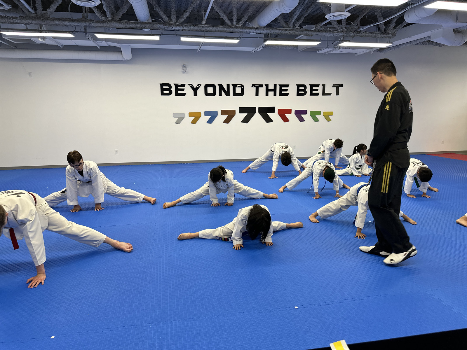 School-age children stretching in focused rows during a taekwondo class at Unity Taekwondo Chilliwack